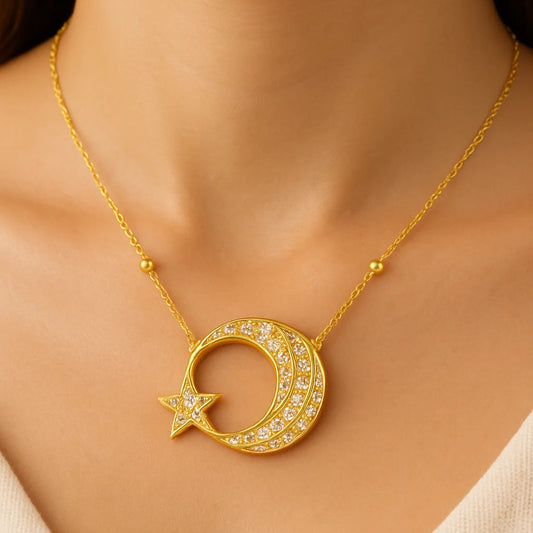 Gold necklace with a crescent moon and star pendant on a model