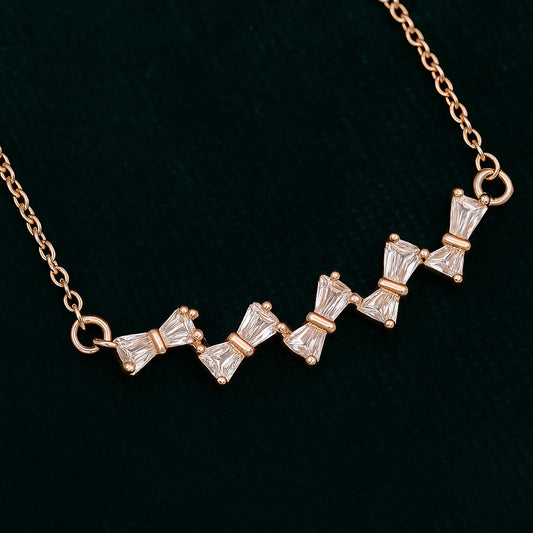 Rose gold necklace with diamond-like stones on a black background