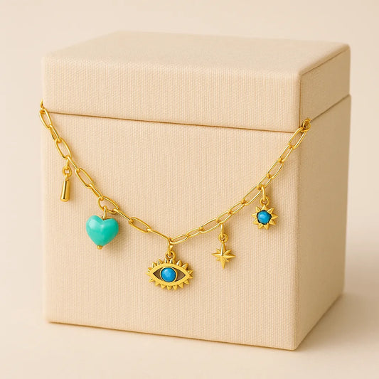 Gold necklace with turquoise charms on a beige box