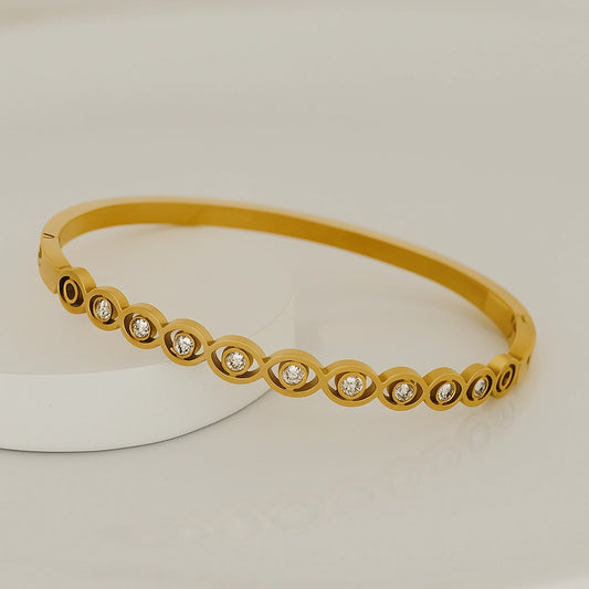 Gold bracelet with embedded diamonds on a light background