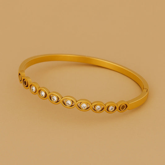 Gold bracelet with embedded diamonds on a beige background