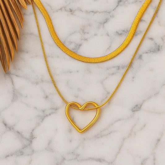 Gold heart-shaped necklace on a marble surface
