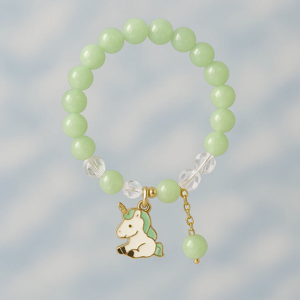 Green beaded bracelet with a unicorn charm on a light gray background