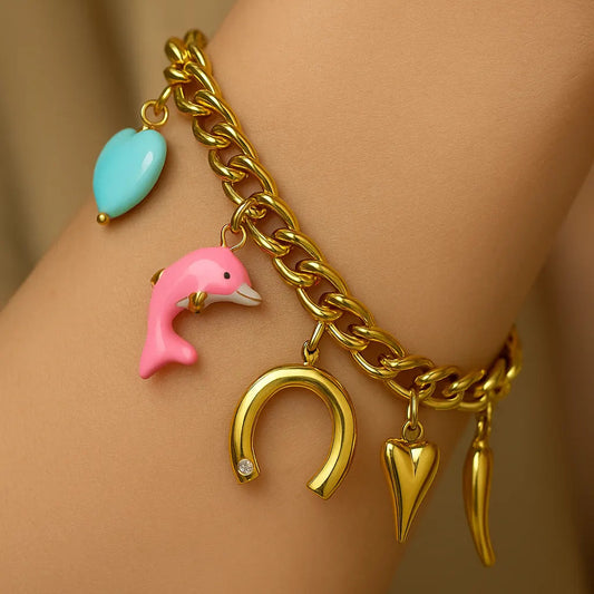 Gold bracelet with colorful charms on a wrist against a beige background