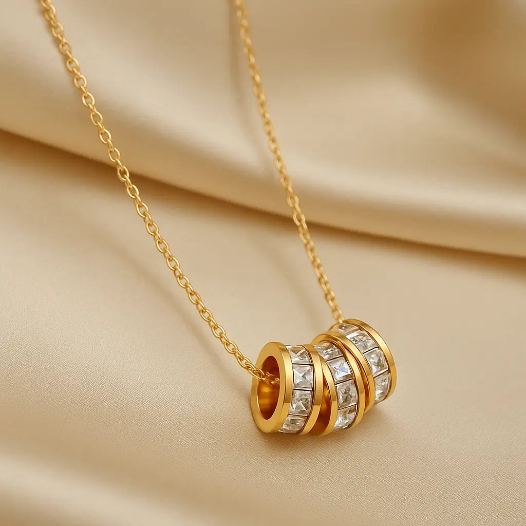 Gold necklace with a detailed pendant on a beige fabric background