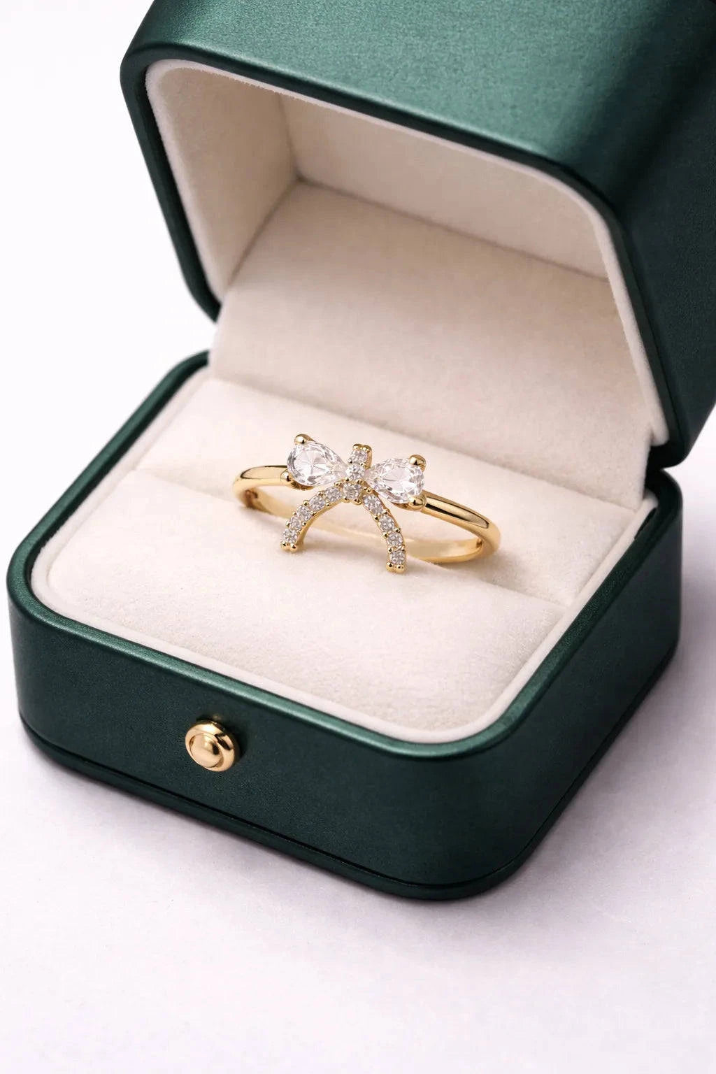 Gold ring with diamond accents in a green jewelry box