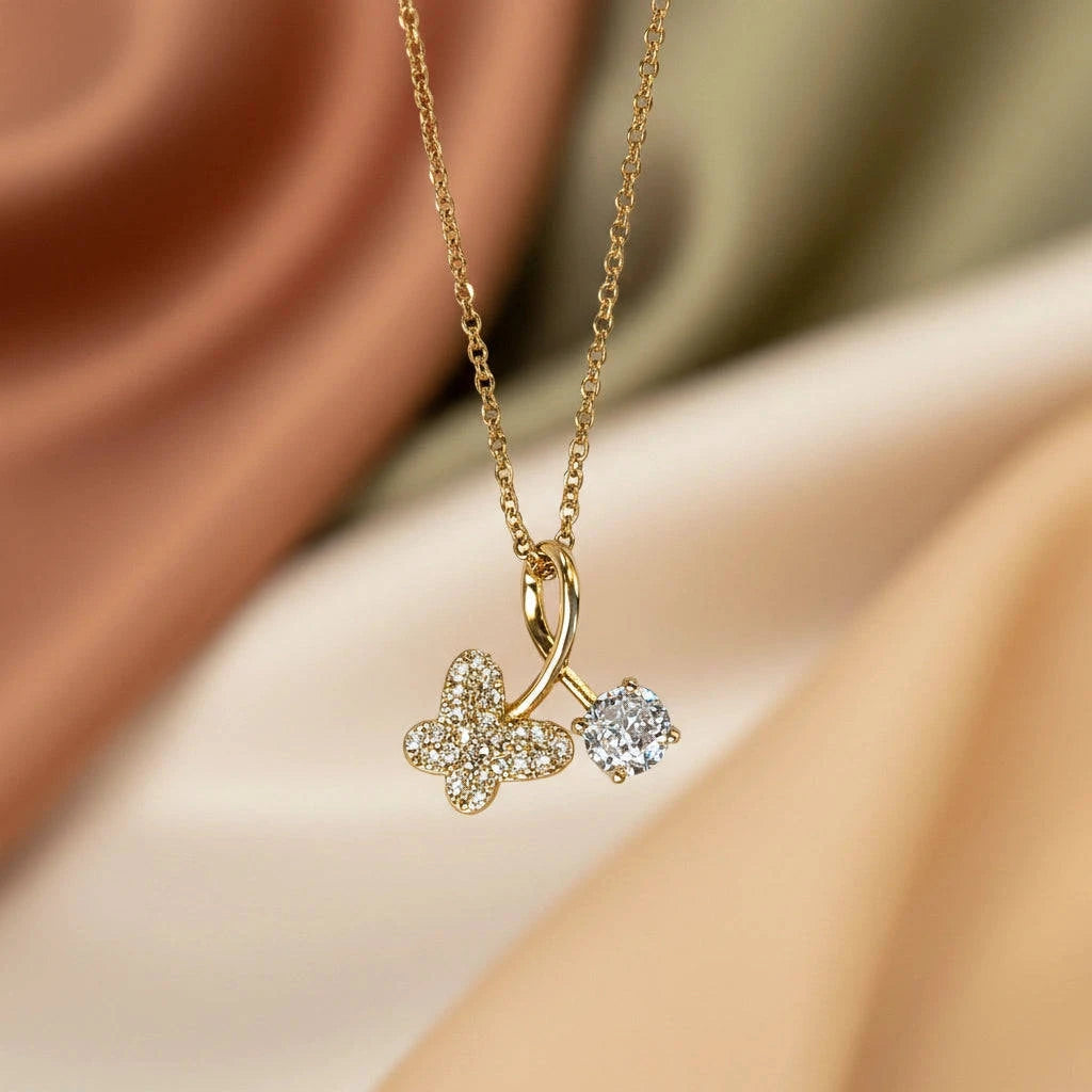 Gold necklace with a clover-shaped pendant on a soft fabric background