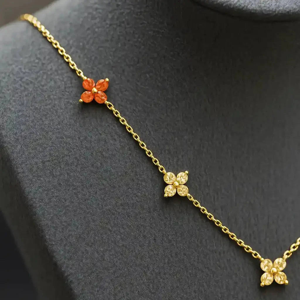 Gold necklace with floral pendants on a gray mannequin bust