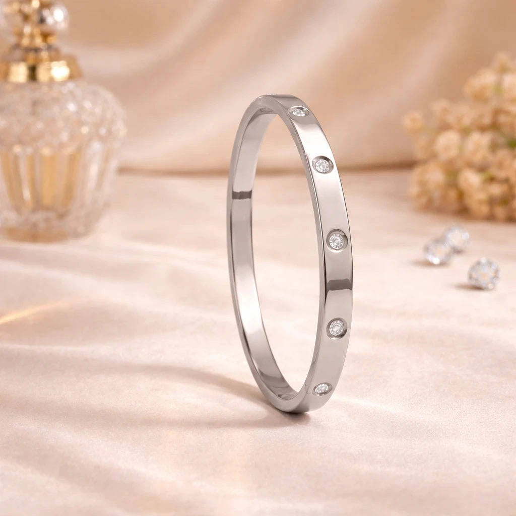 Silver ring with embedded stones on a soft beige background