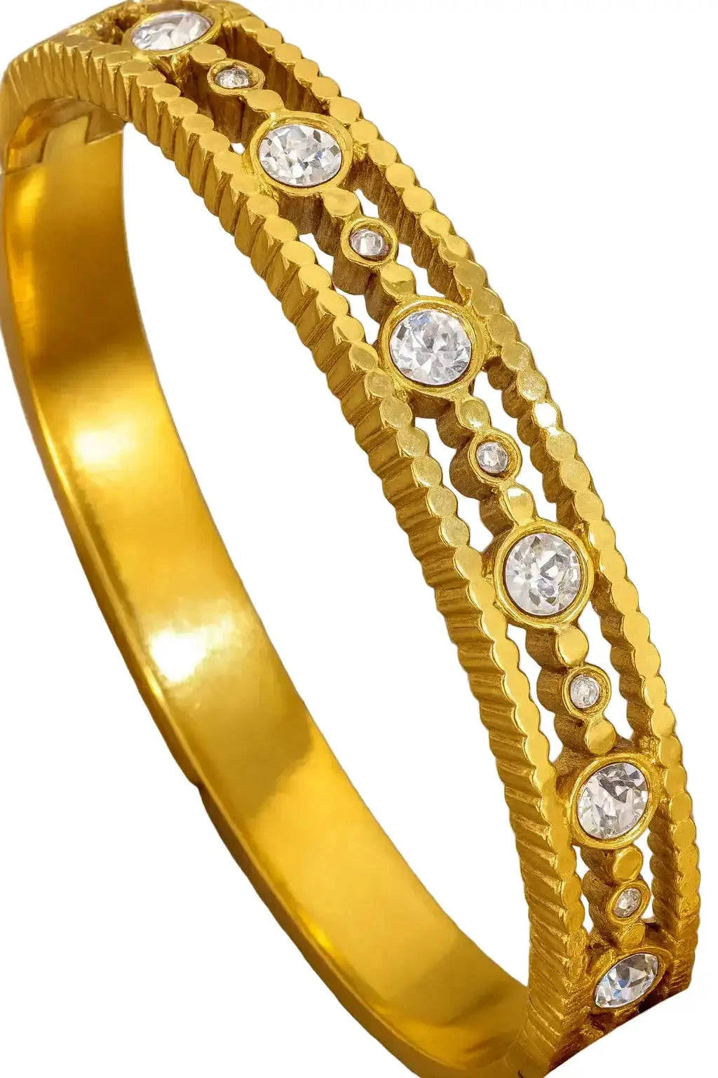 Gold bracelet with embedded crystals on a beige background