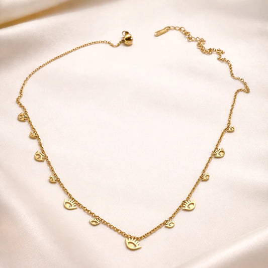 Gold necklace with heart pendants on a beige fabric background