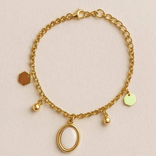 Gold bracelet with various charms on a beige background