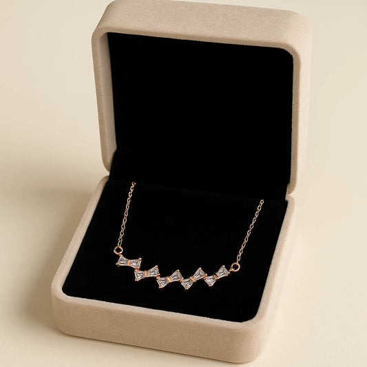 Necklace with diamond accents in a jewelry box on a beige background