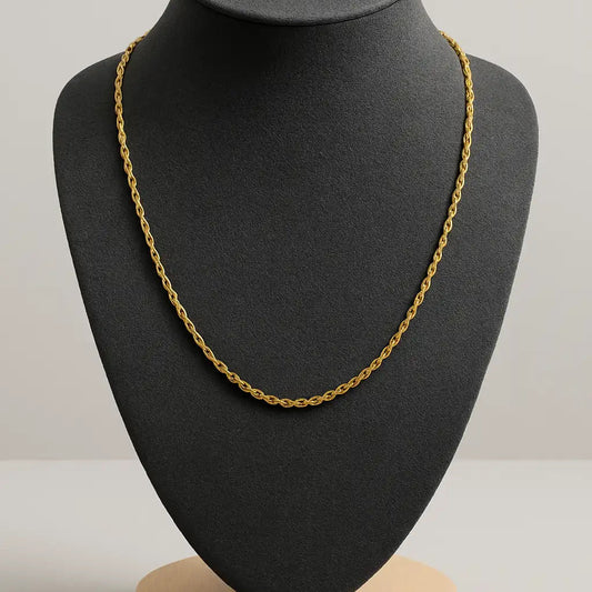 Gold chain necklace on a black mannequin bust with a gray background