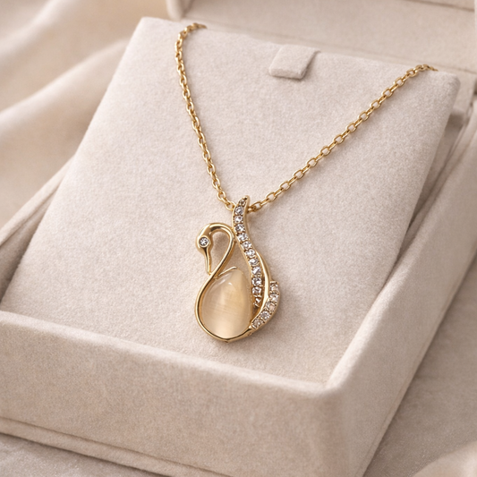 Gold necklace with a pendant on a beige jewelry box