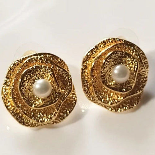 Pair of gold earrings with pearl centers on a white background