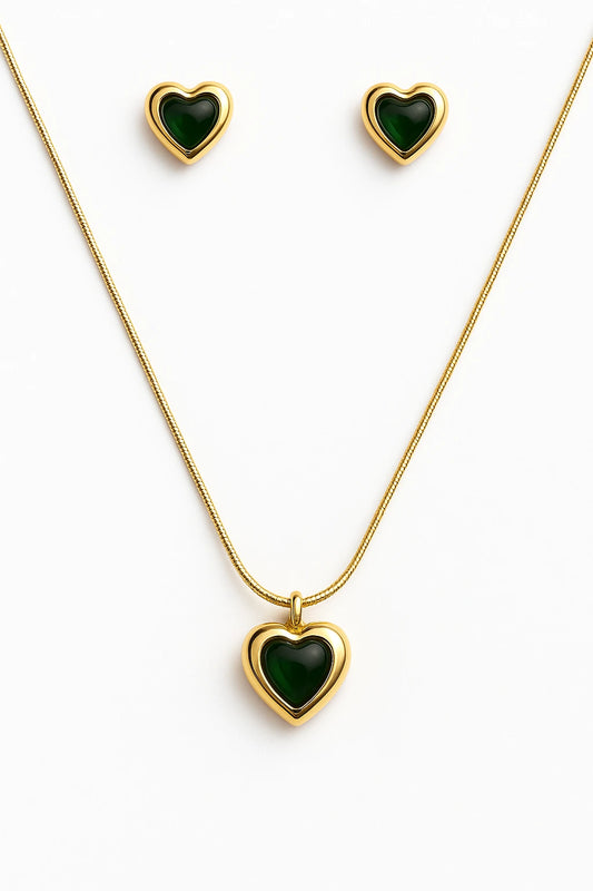 Gold necklace and earrings with green heart-shaped stones on a white background