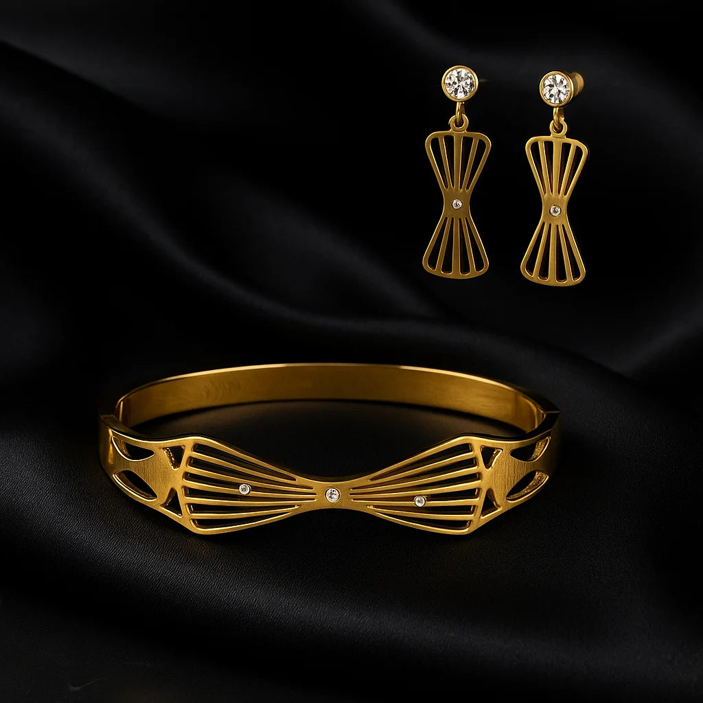 Gold bracelet and earrings on black satin fabric