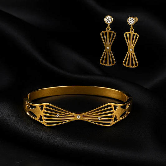 Gold bracelet and earrings on black satin fabric