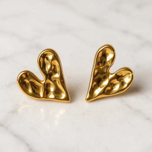 Pair of gold heart-shaped earrings on a light background