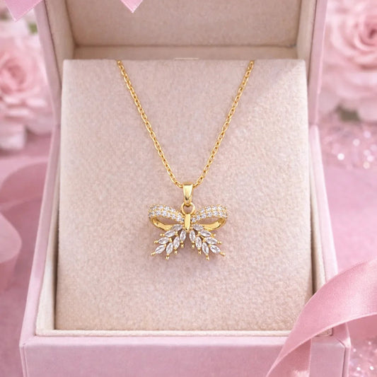 Gold butterfly necklace in a pink box with a pink ribbon