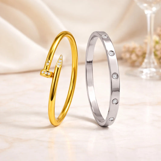 Gold and silver bangles with diamond accents on a soft fabric background