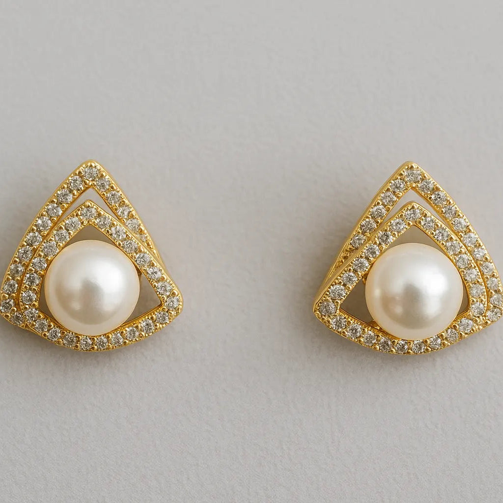 Pair of gold-trimmed pearl earrings on a light gray background