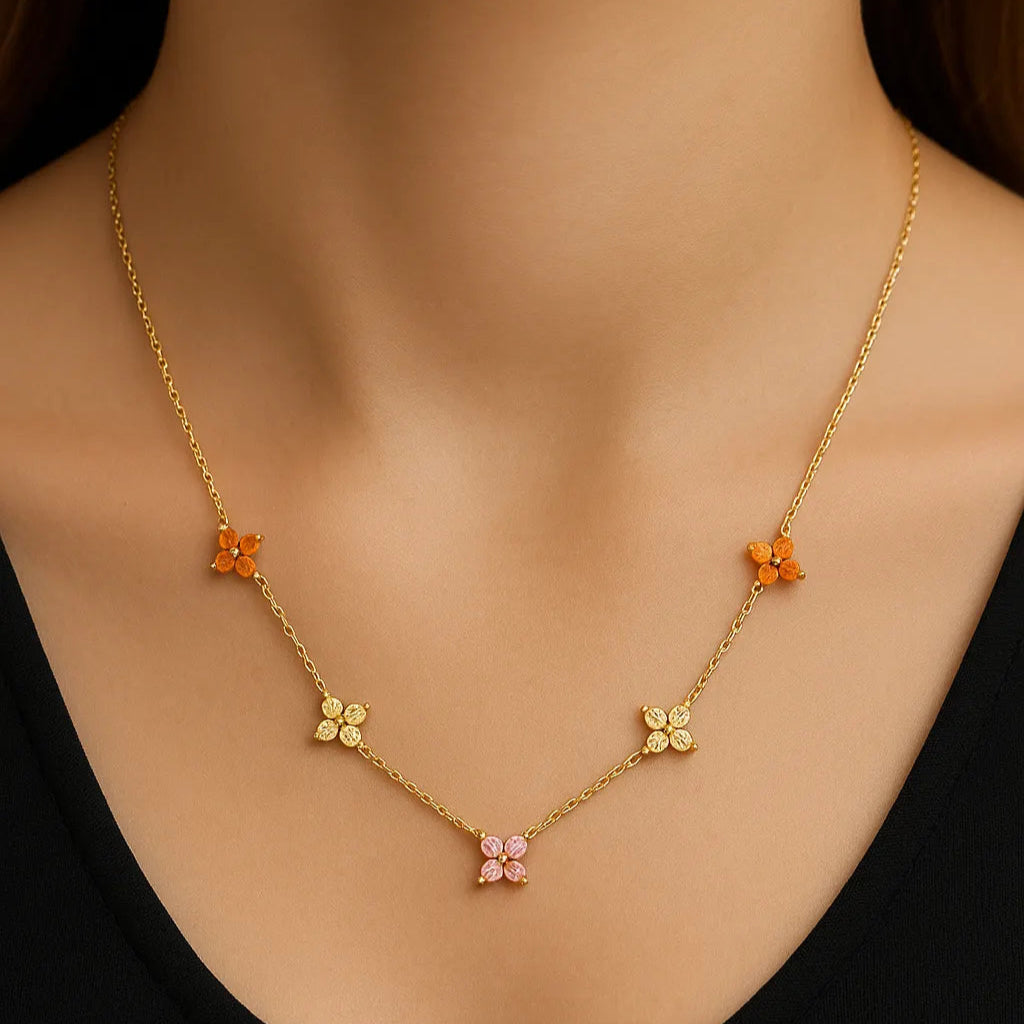 Gold necklace with floral pendants on a black background