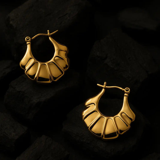 Gold hoop earrings on a dark textured background