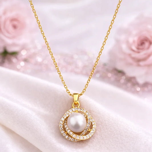 Gold necklace with a pearl pendant on a white fabric background