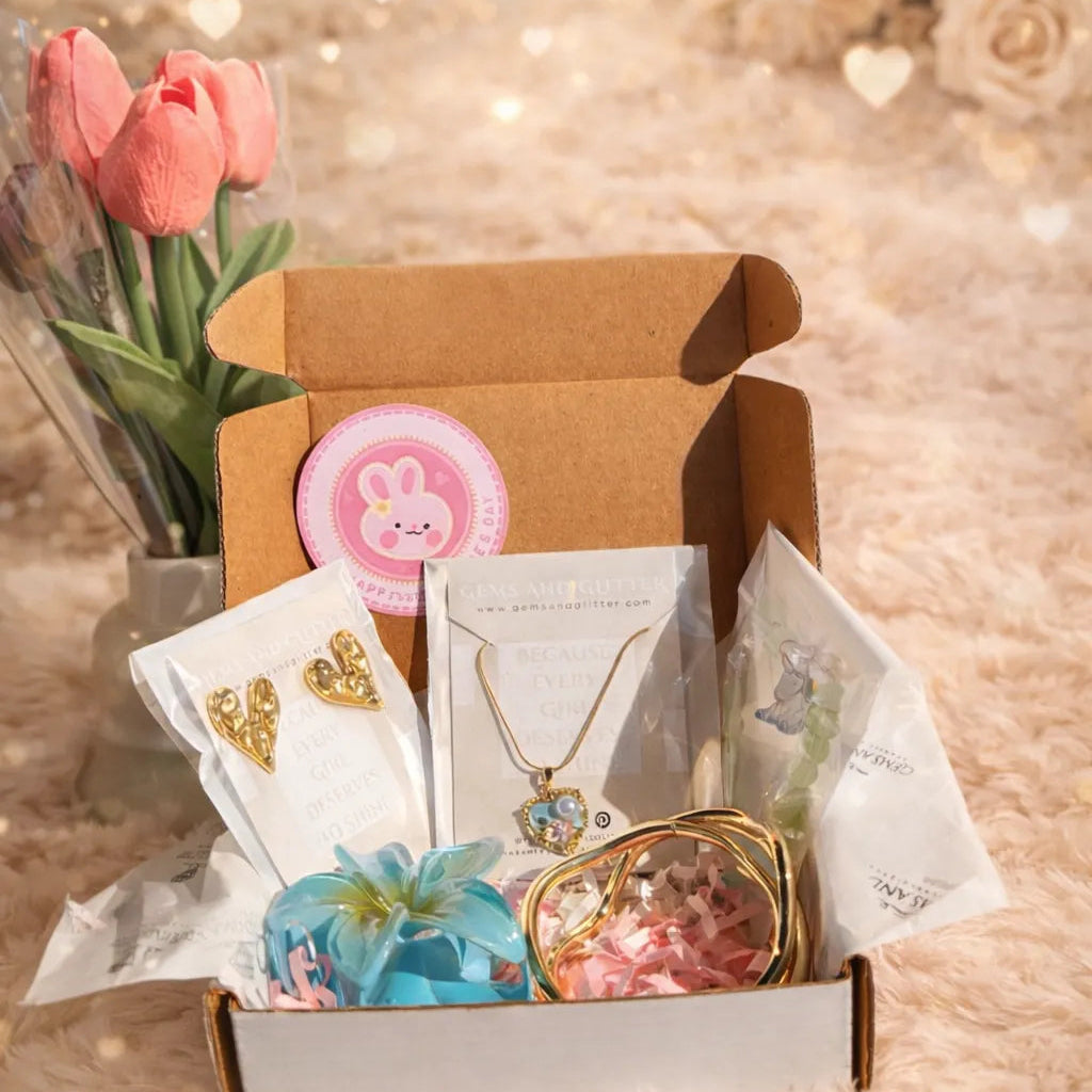 Open gift box with jewelry, flowers, and cards on a soft background