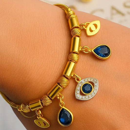 Gold bracelet with blue gemstones on a wrist against a light background