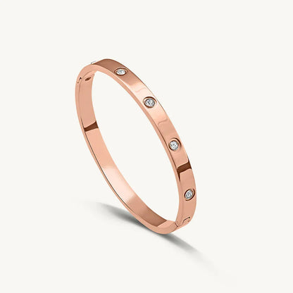 Rose gold bracelet with diamonds on a light gray background