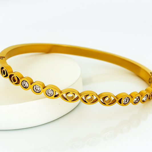 Gold bracelet with embedded stones on a white background