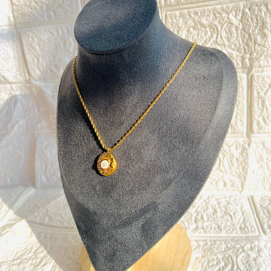 Gold necklace on a gray mannequin bust against a textured white wall.