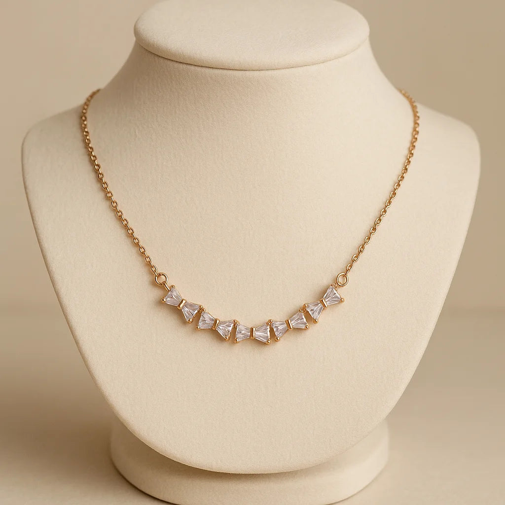 Gold necklace with clear stones on a beige mannequin bust