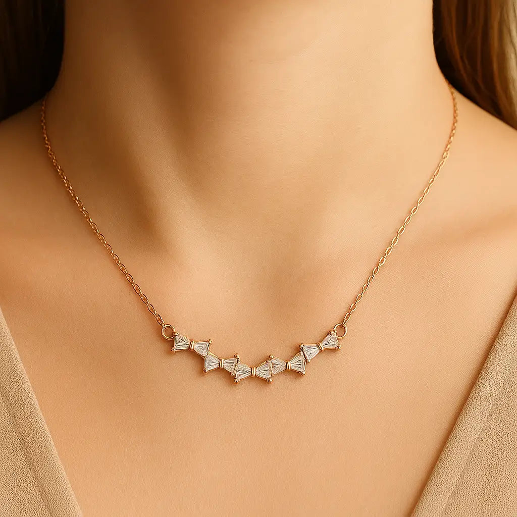 Gold necklace with diamond-like stones on a model wearing a beige top.
