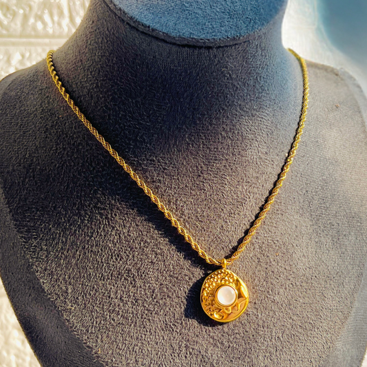 Gold necklace with a pendant on a mannequin bust
