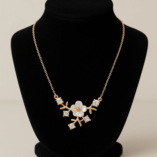Gold necklace with floral design on a black mannequin bust