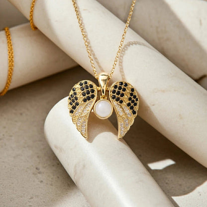 Gold necklace with a leaf-shaped pendant on a marble surface