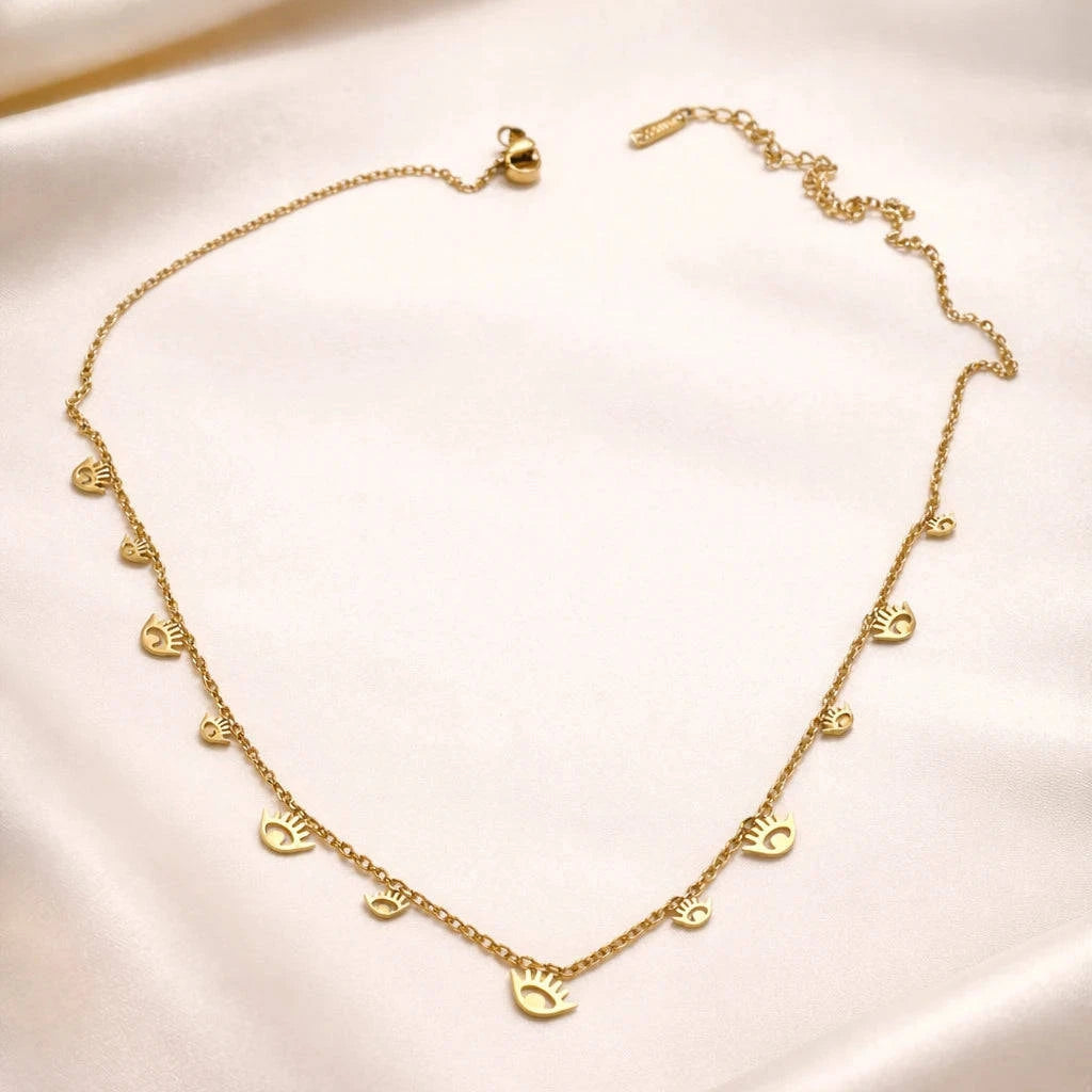 Gold necklace with heart pendants on a beige fabric background
