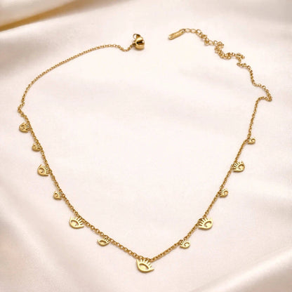 Gold necklace with heart pendants on a beige fabric background