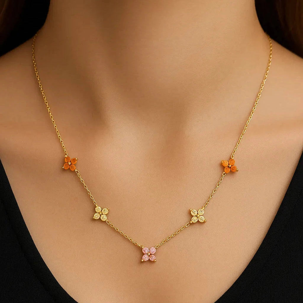Gold necklace with floral pendants on a black background