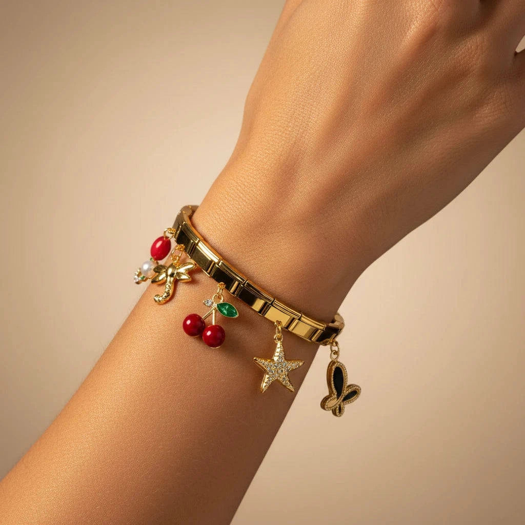 Gold bracelet with charms on a wrist against a beige background