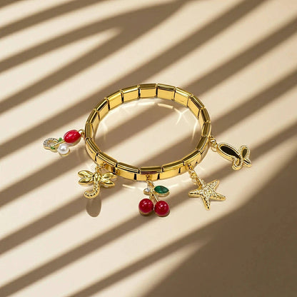 Gold bracelet with various charms on a beige background
