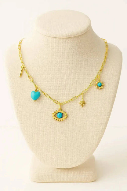 Gold necklace with turquoise heart and eye-shaped charms on a mannequin bust.