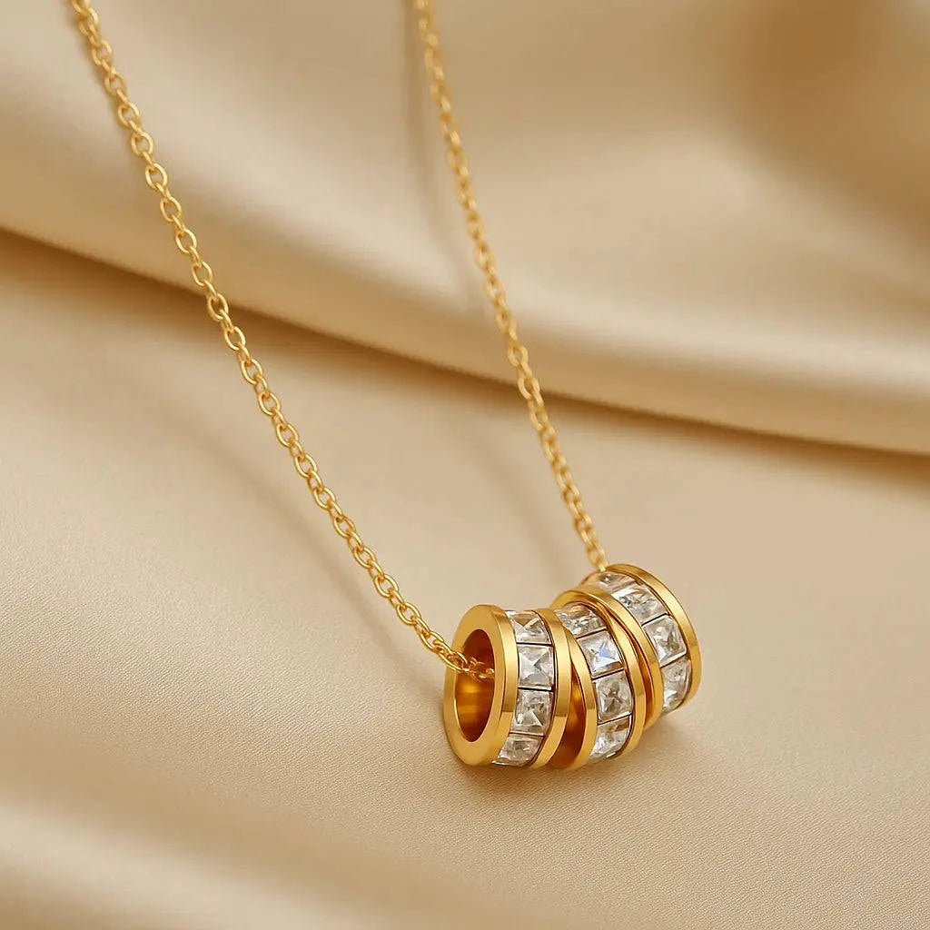 Gold necklace with a detailed pendant on a beige fabric background