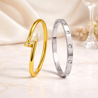 Gold and silver bangles with diamond accents on a soft fabric background