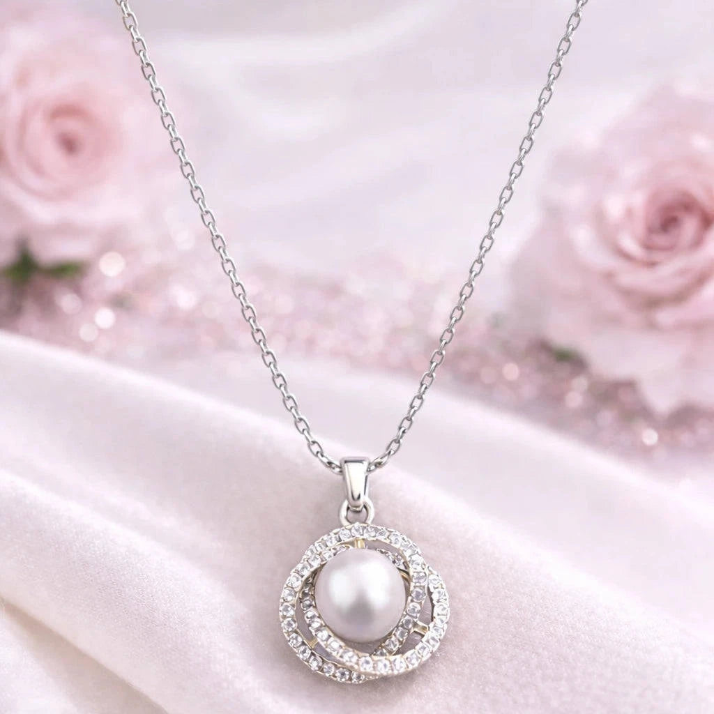 Pearl necklace with silver chain on a white fabric background