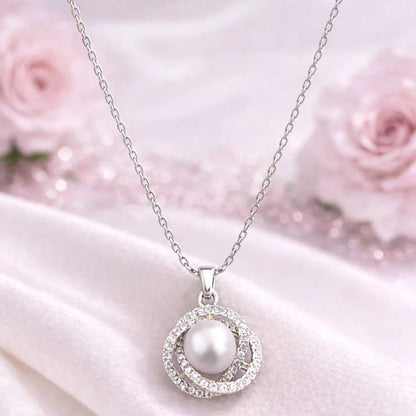 Pearl necklace with silver chain on a white fabric background